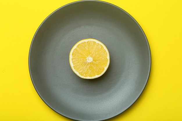 Illuminando il giallo limone su un piatto grigio definitivo. Colori dell'anno 2021