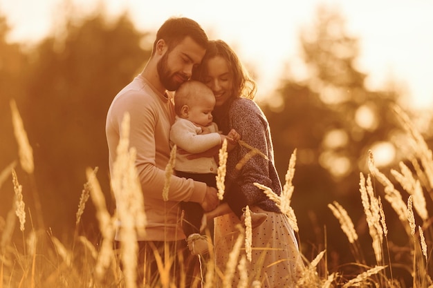 Illuminato dalla luce del sole La famiglia felice della famiglia madre e del piccolo bambino riposa all'aperto Bella soleggiata natura autunnale