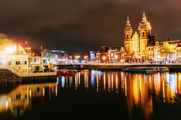 Illuminazione notturna di edifici e barche vicino all'acqua nel canale.