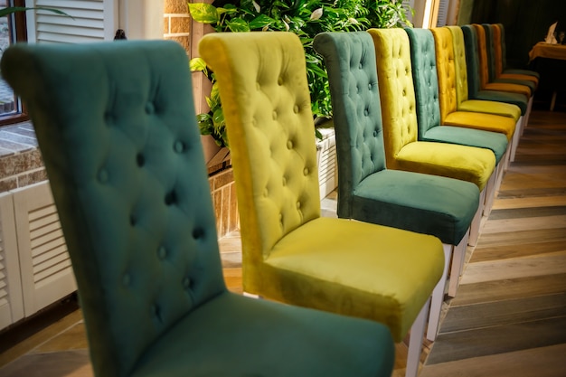 Illustrazione del salone interno moderno. fila di facile sedia in tessuto contro la parete e il pavimento blu pastello. sfondo del soggiorno. sedia verde al centro.