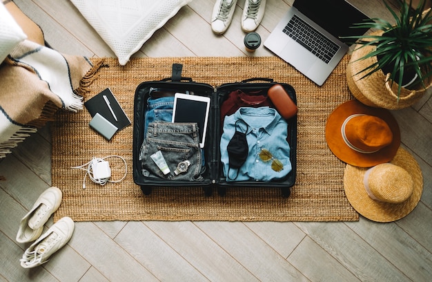 Imballaggio della valigia per le vacanze di viaggio nella nuova vista normale e dall'alto.