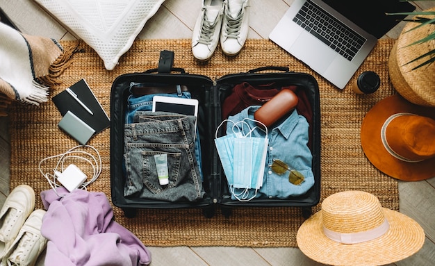 Imballaggio della valigia per le vacanze di viaggio nella nuova vista normale e dall'alto.