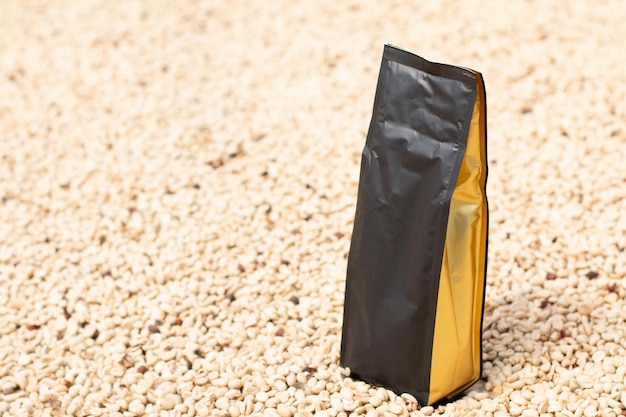 Imballaggio moderno del sacchetto del caffè sull'essiccazione dei chicchi di caffè Sacchetto del caffè nero con oro Fotografia del prodotto