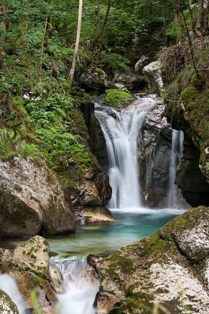 Immagine a lunga esposizione di un bellissimo flusso d'acqua che cade dalle rocce coperte di muschio