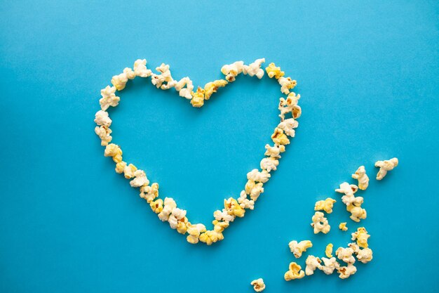 Immagine alimentare delle forme del cuore da Popcorn Delicious Popcorn su sfondo blu Cinema