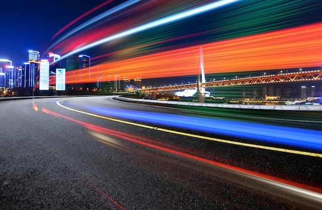 Immagine astratta di movimento della sfocatura delle automobili sulla strada di città alla notte, architettura urbana moderna a Chongqing, Cina