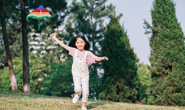 Immagine Bambina asiatica che gioca aquilone nel parco