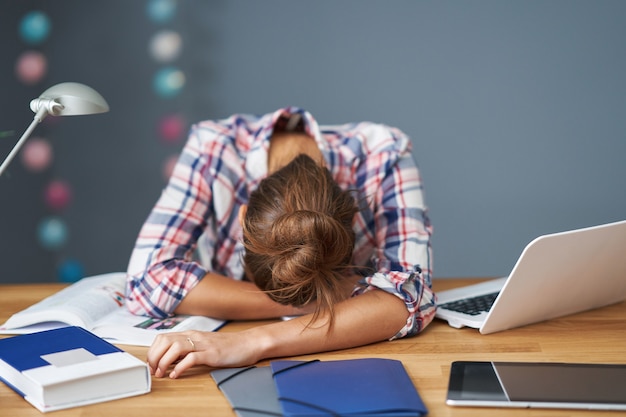 Immagine che mostra una studentessa stanca che impara tardi a casa