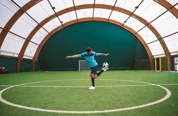 Immagine cinematografica di un giocatore di calcio freestyle che fa acrobazie con la palla