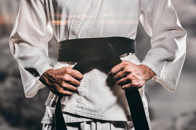 Immagine composita del combattente che stringe la cintura di karate