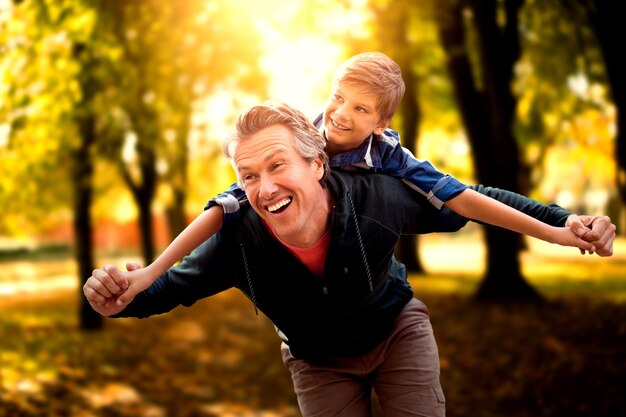 Immagine composita del padre che dà a suo figlio un giro sulle spalle