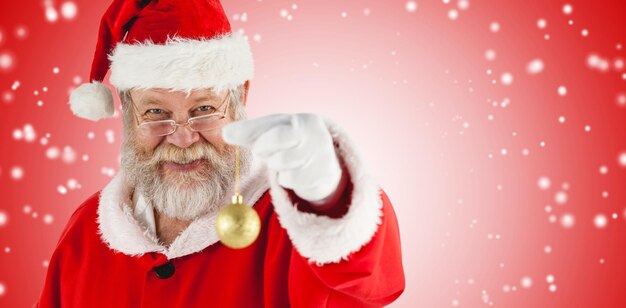 Immagine composita del ritratto di Babbo Natale allegro che tiene la pallina di natale