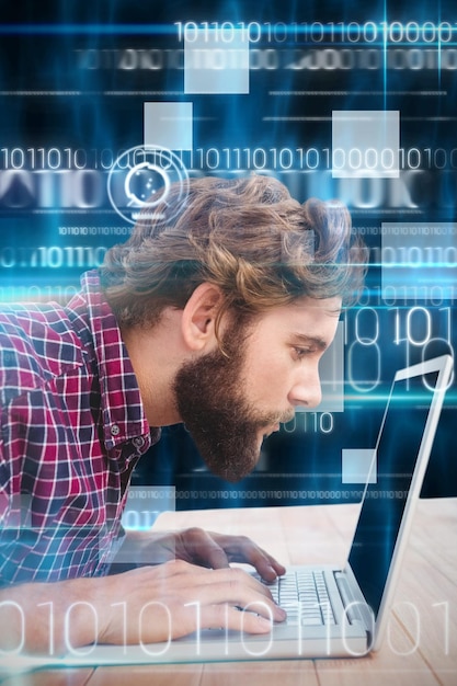 Immagine composita dell'uomo concentrato che lavora al computer portatile