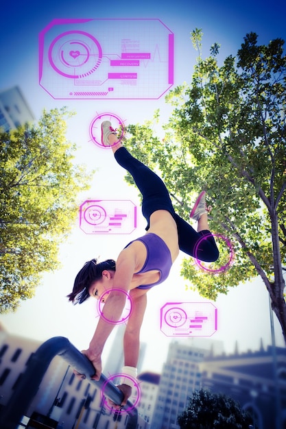 Immagine composita della donna atletica che esegue verticale sulla barra