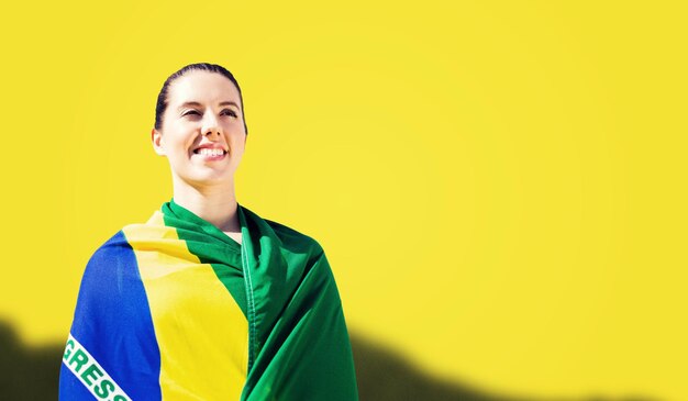 Immagine composita della donna sportiva che tiene bandiera brasiliana