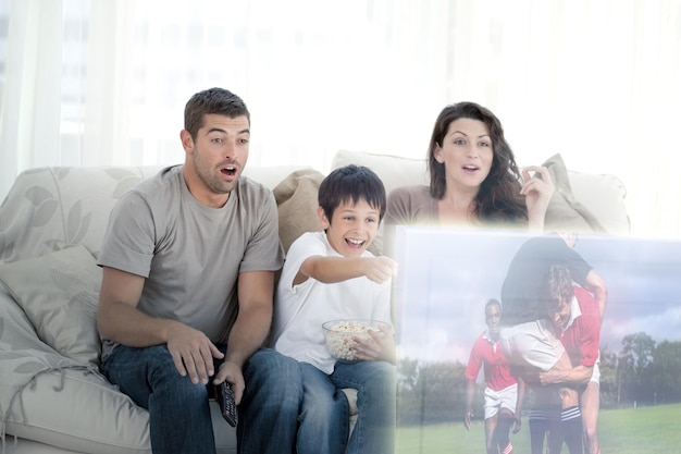 Immagine composita della famiglia felice che guarda la televisione