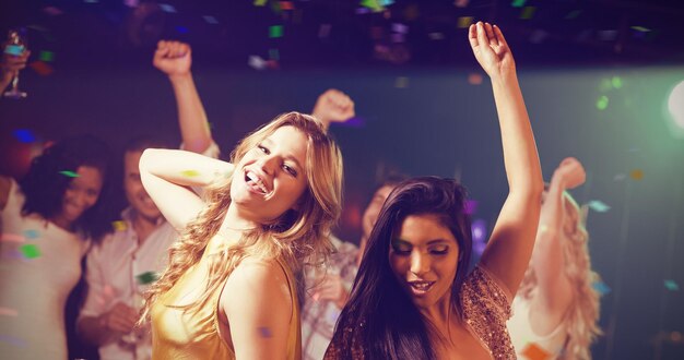 Immagine composita di amici che tengono champagne mentre ballano