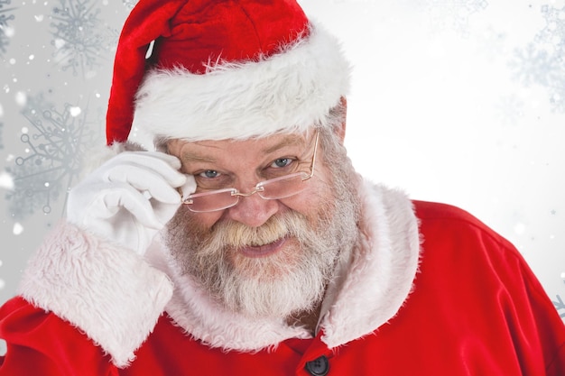 Immagine composita di Babbo Natale che tiene gli occhiali