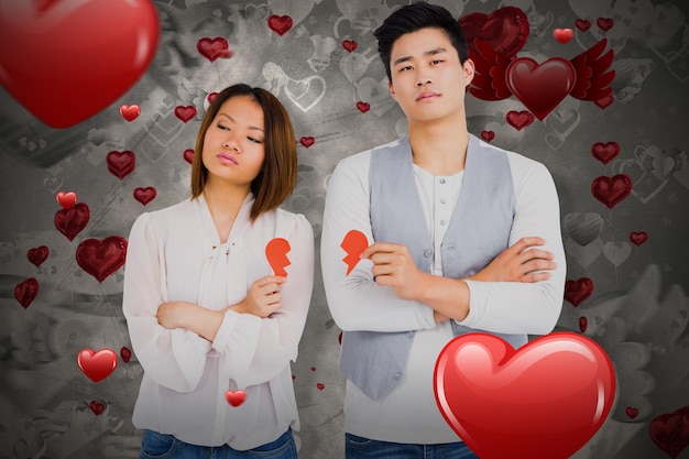 Immagine composita di giovani coppie che tengono cuore spezzato 3D