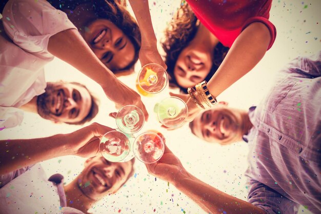 Immagine composita di un'immagine direttamente sotto di amici che bevono un cocktail in piedi