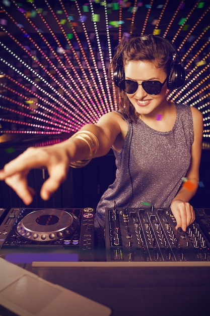 Immagine composita di una bella femmina dj che suona musica