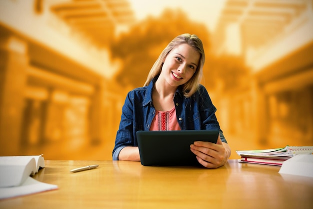 Immagine composita di uno studente che studia in biblioteca con tablet