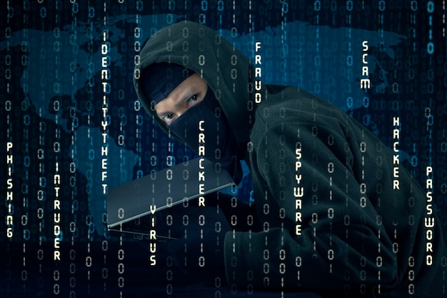 Immagine composita digitale di un hacker con un laptop