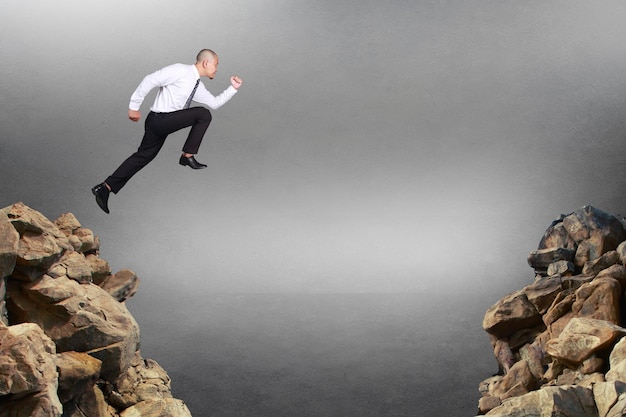 Immagine composita Uomo d'affari che corre saltando attraverso un buco di ostacoli concetto di rischio aziendale