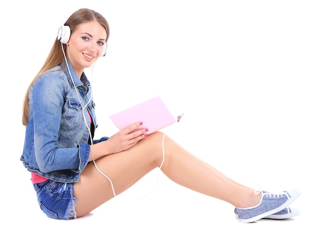 Immagine concettuale del libro audioBella ragazza con il libro e le cuffie isolate su bianco