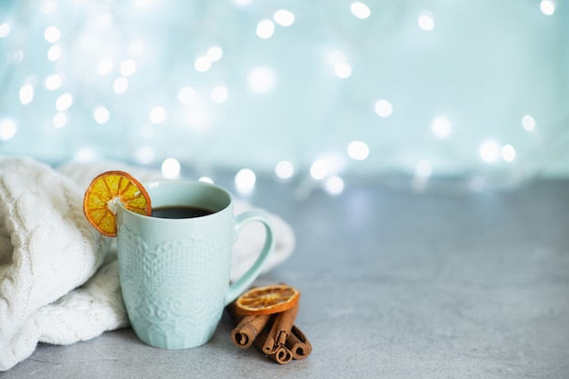 Immagine creativa di cioccolata calda con crema e stecca di cannella in una tazza di ceramica rustica blu.