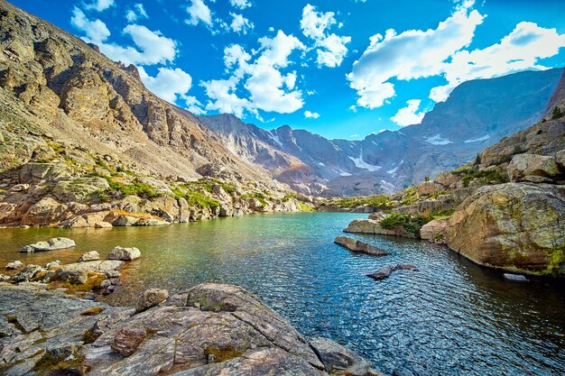 Immagine del lago di montagna circondato da massi e licheni