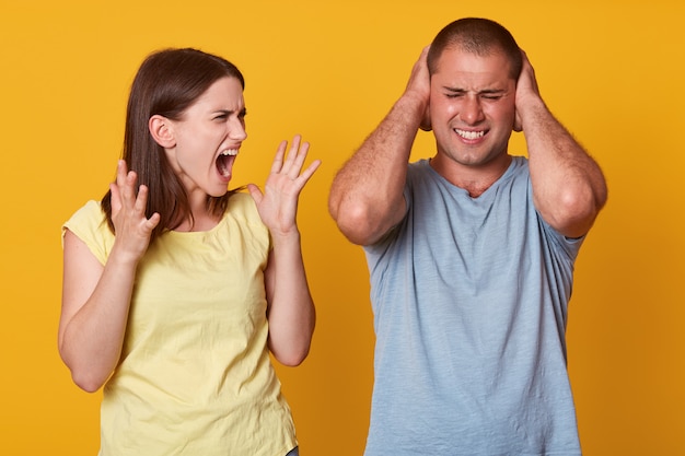 Immagine del litigio di coppia, irritata donna urla arrabbiata che apre la bocca ampiamente,