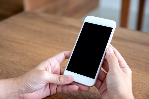 Immagine del modello delle mani che tengono il telefono cellulare bianco con schermo nero vuoto