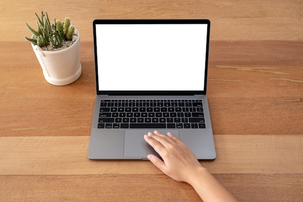 Immagine del modello delle mani utilizzando e toccando il touchpad del laptop con lo schermo del desktop bianco vuoto sul tavolo di legno