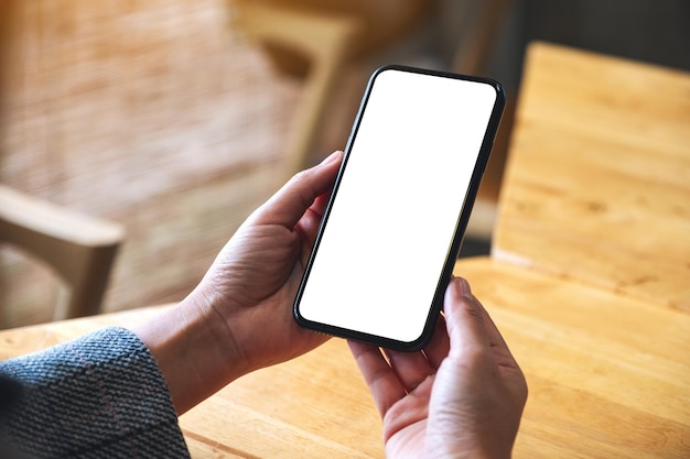 Immagine del modello di una donna che tiene il telefono cellulare con lo schermo del desktop bianco vuoto