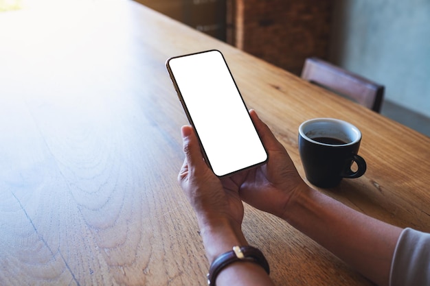 Immagine del modello di una donna che tiene il telefono cellulare con lo schermo del desktop bianco vuoto