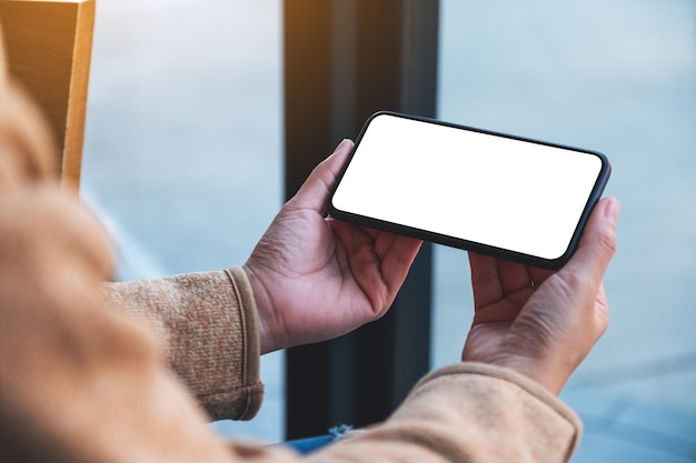 Immagine del modello di una donna che tiene il telefono cellulare con lo schermo del desktop bianco vuoto