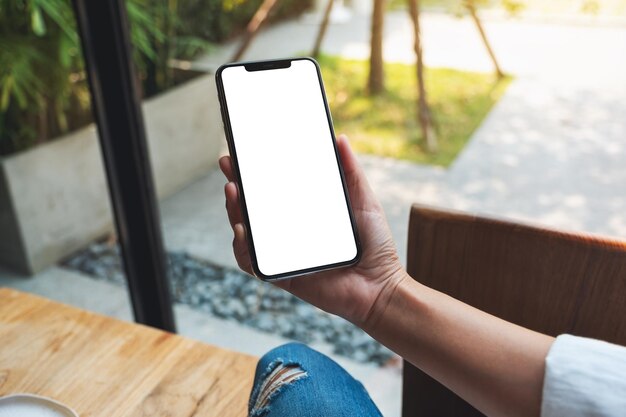 Immagine del modello di una donna che tiene il telefono cellulare con lo schermo del desktop bianco vuoto