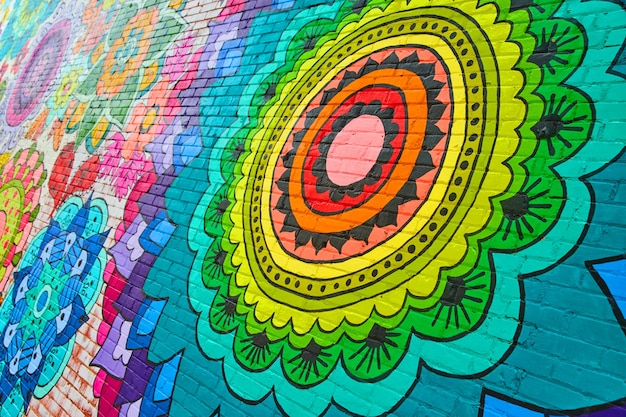 Immagine del murale dipinto con fiori arcobaleno su un muro di mattoni