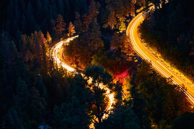 Immagine del paesaggio notturno delle strade di montagna e sfocatura delle auto che guidano