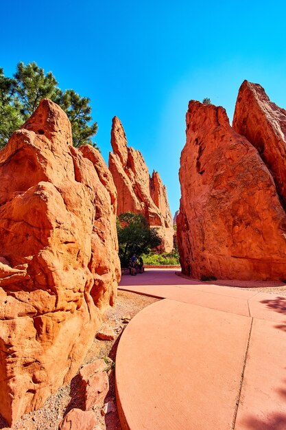 Immagine del percorso pedonale lastricato attraverso grandi colonne rosse di roccia e cielo blu