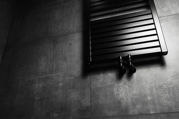 Immagine del portasciugamani riscaldato nero opaco in bagno con pareti grigio scuro