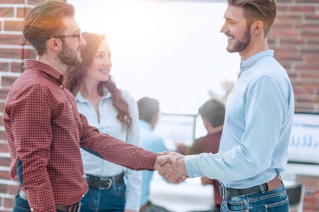 Immagine del primo piano dei partner commerciali che fanno la stretta di mano in un ufficio