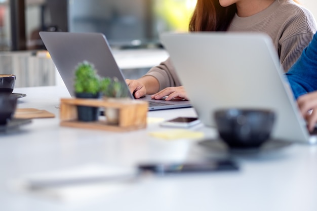 Immagine del primo piano dell'uomo d'affari che utilizza e lavora insieme al computer portatile in ufficio