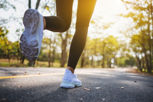 Immagine del primo piano delle gambe di una donna mentre fa jogging nel parco cittadino al mattino