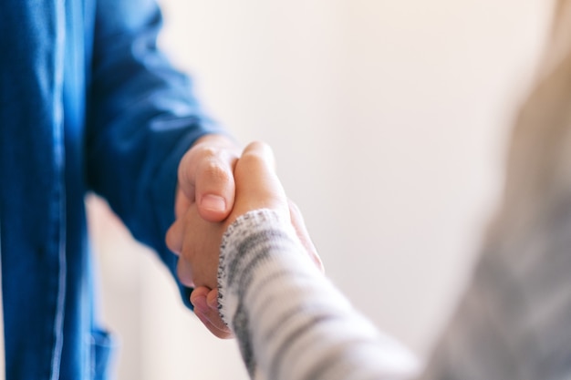 Immagine del primo piano di due persone che si stringono la mano