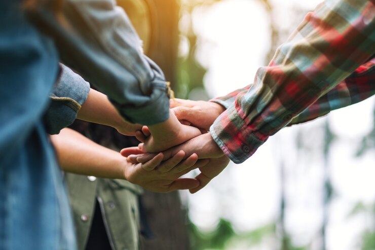 Foto immagine del primo piano di persone che uniscono le mani all'aperto