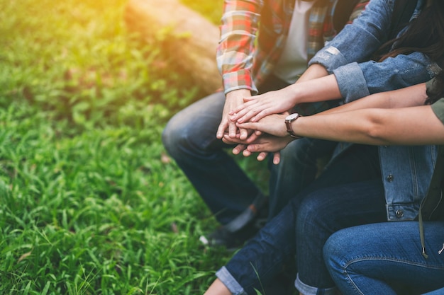 Immagine del primo piano di persone che uniscono le mani all'aperto