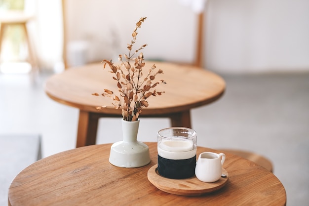 Immagine del primo piano di un bicchiere di caffè latte sul tavolo di legno in un caffè minimo