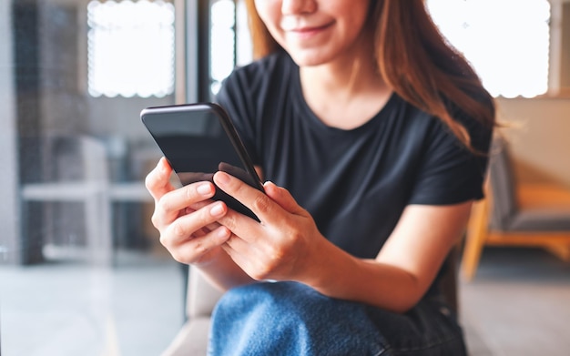 Immagine del primo piano di una bella giovane donna asiatica che tiene e utilizza il telefono cellulare